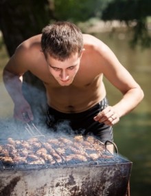 Junger Mann am Grill