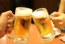 Zwei Biergläser beim Anstoßen